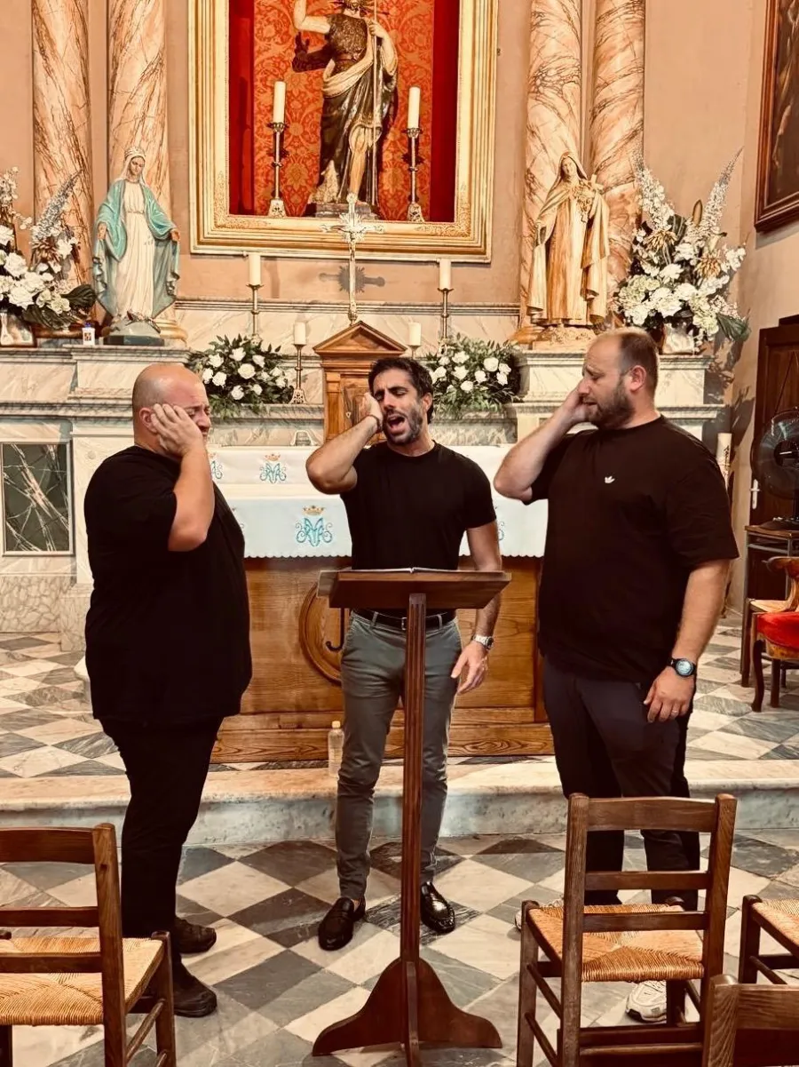 Trois chanteurs corses en polyphonie devant l’autel d’une église en Corse